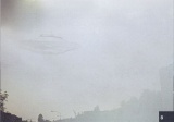 Photo Inventarium 2014 - cat no. #8. 20th May, 1975 at 15:00. Beamship of Semjase over the Wihaldenstrasse in the north in Hinwil, Switzerland. The ship is semi-transparent. The proximity of the vessel and its vibrations may have affected the quality of the film.[87]